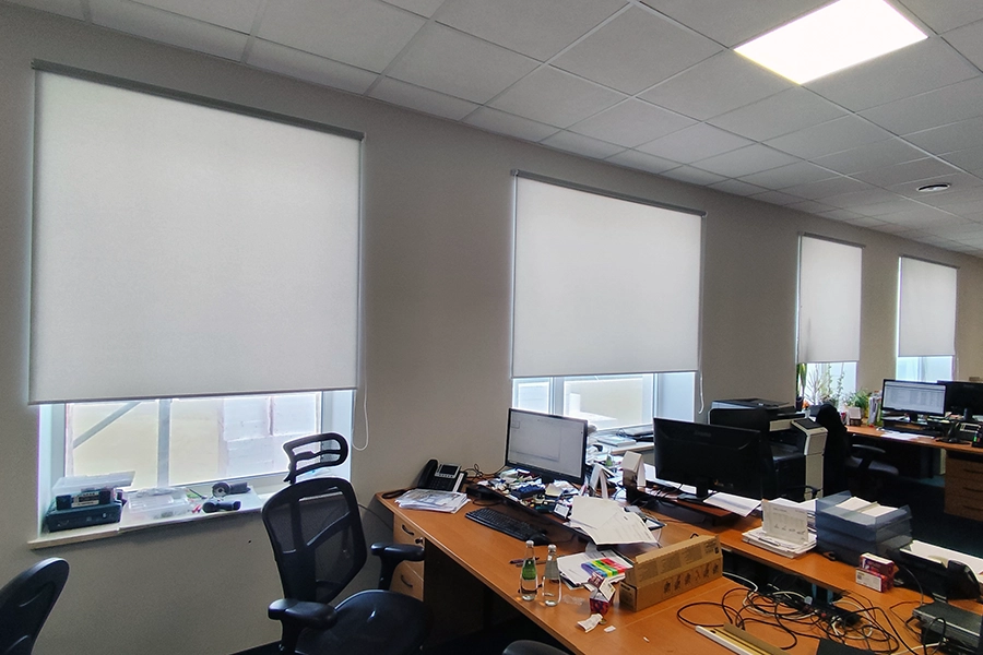 Rolety wolnowiszące w biurze – jasne rolety materiałowe montowane na ścianie