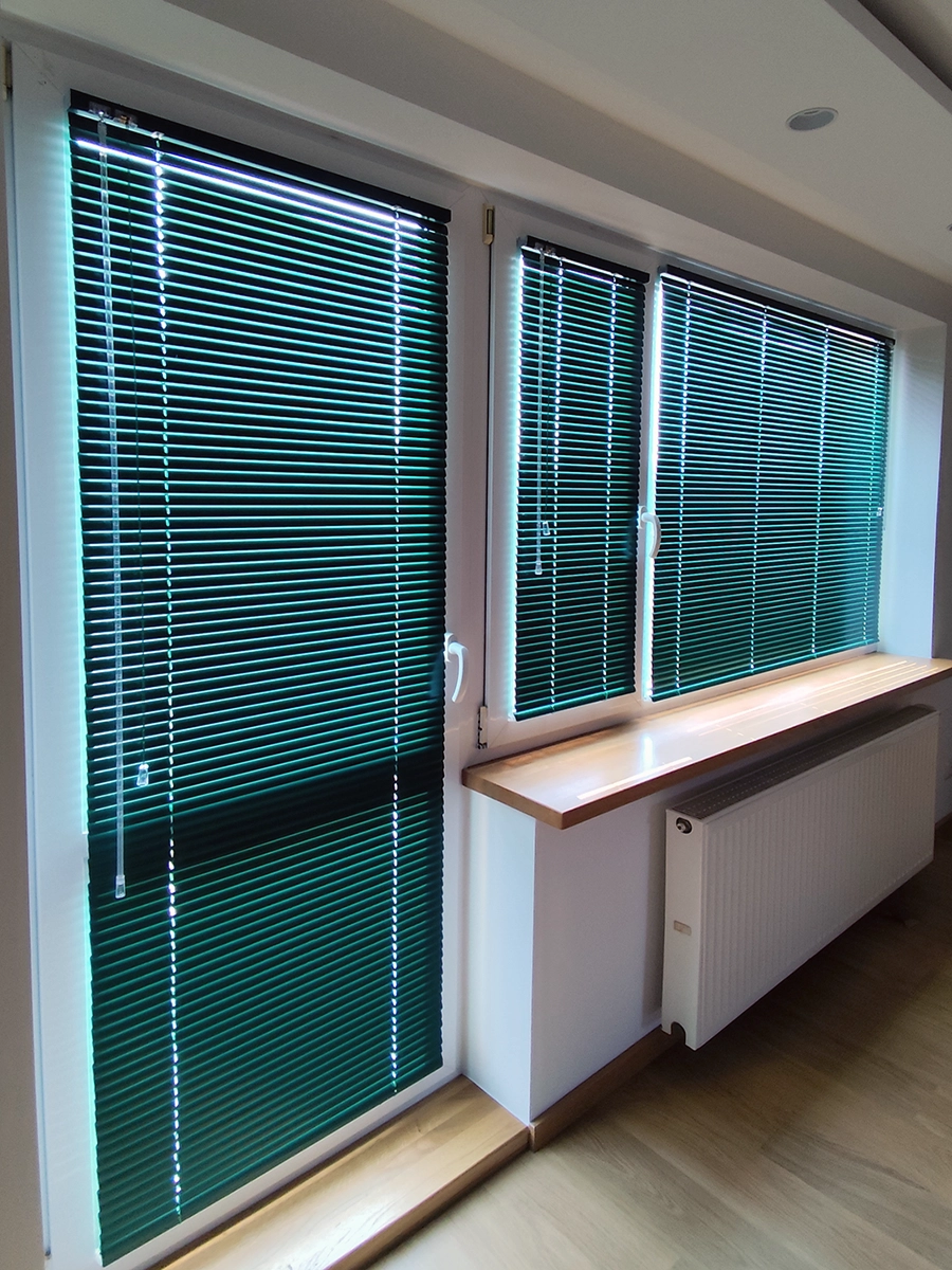 Zielone żaluzje aluminiowe na kilku oknach i drzwiach – realizacja wnętrza