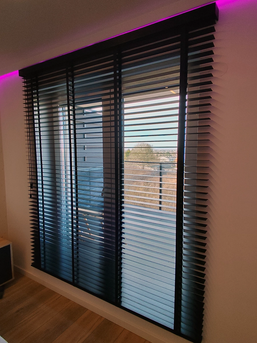 Czarne żaluzje drewniane 50 mm na dużym oknie balkonowym